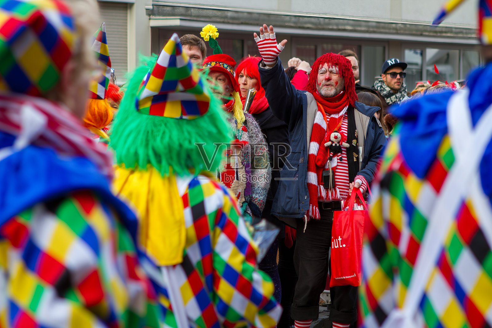 戴红色假发和红白条纹围巾的男子照片摄影图片