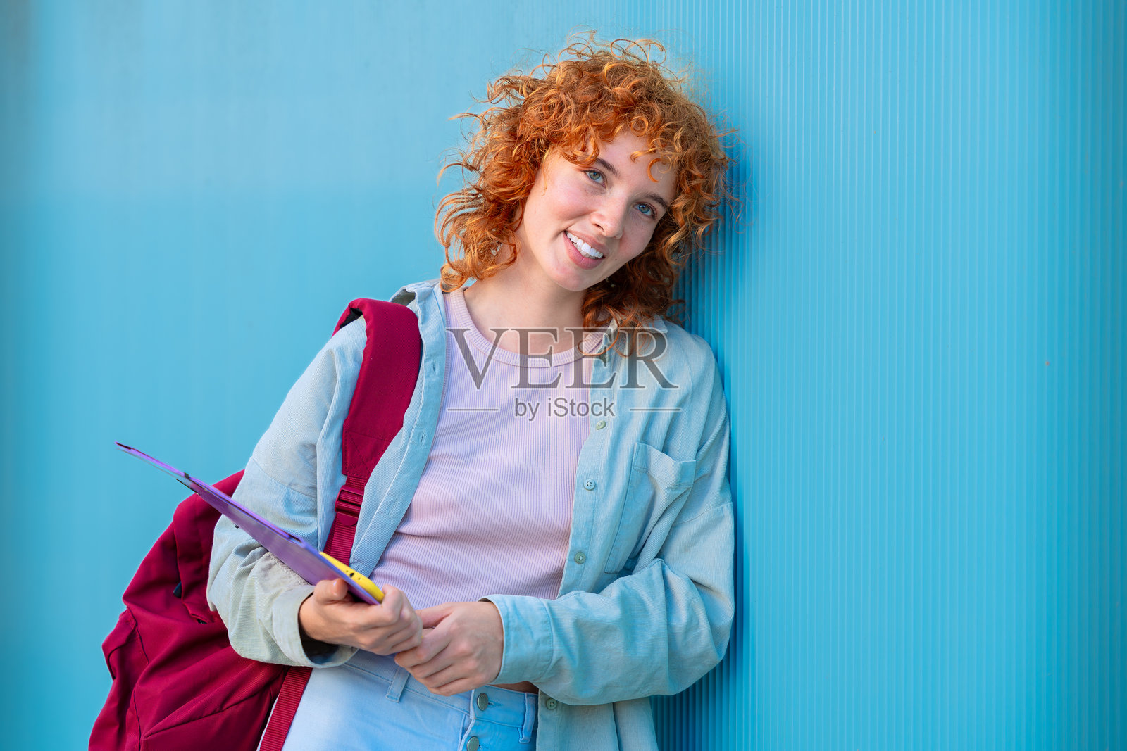 快乐的年轻白人女学生拿着笔记本看着镜头照片摄影图片