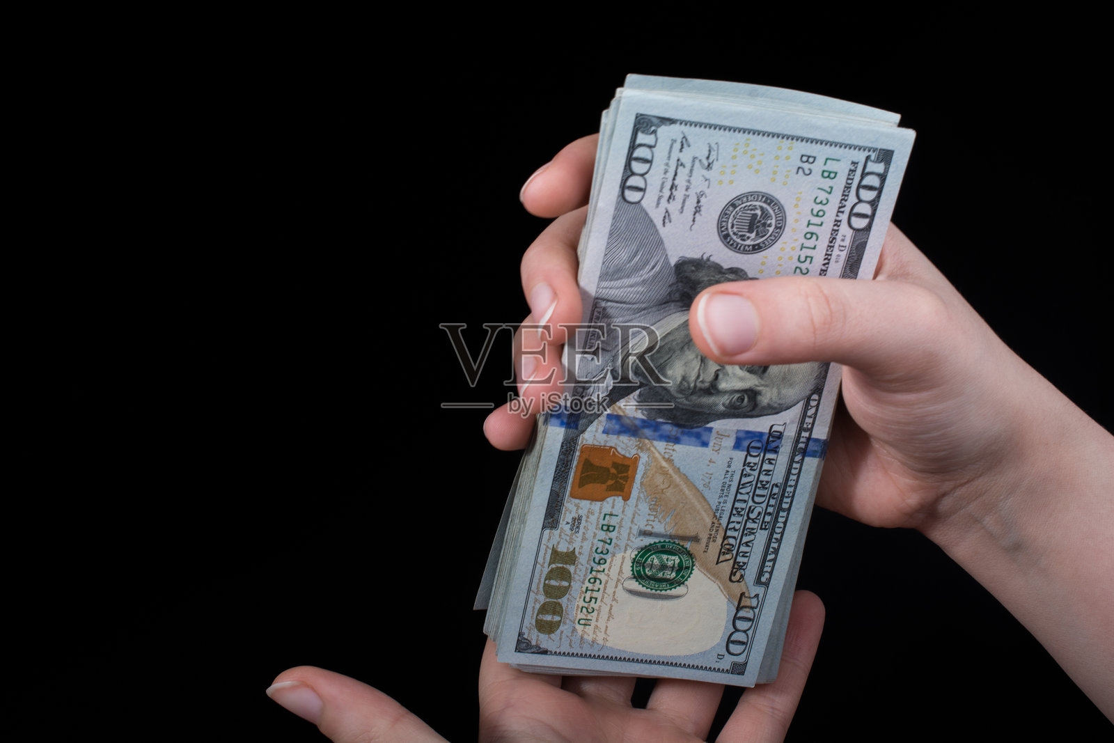 黑色背景下的手握纸币特写照片摄影图片