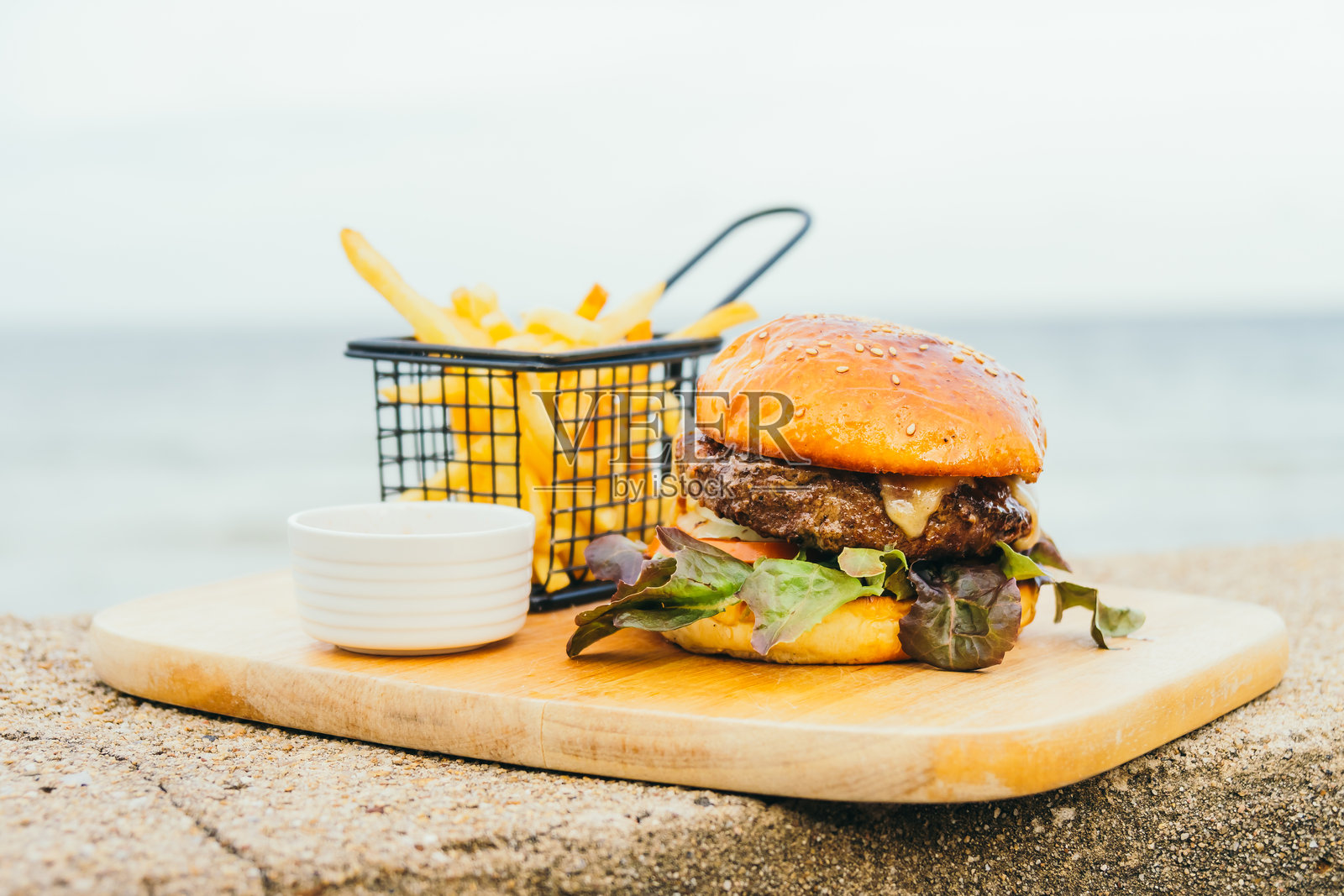 海滩上切板上的汉堡特写照片摄影图片