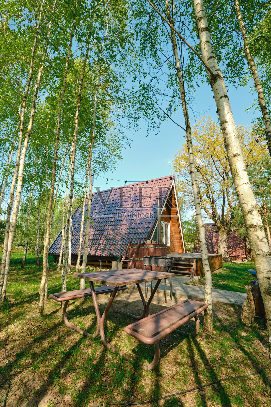 被树木环绕的舒适小屋，户外宁静环境中的野餐桌照片摄影图片