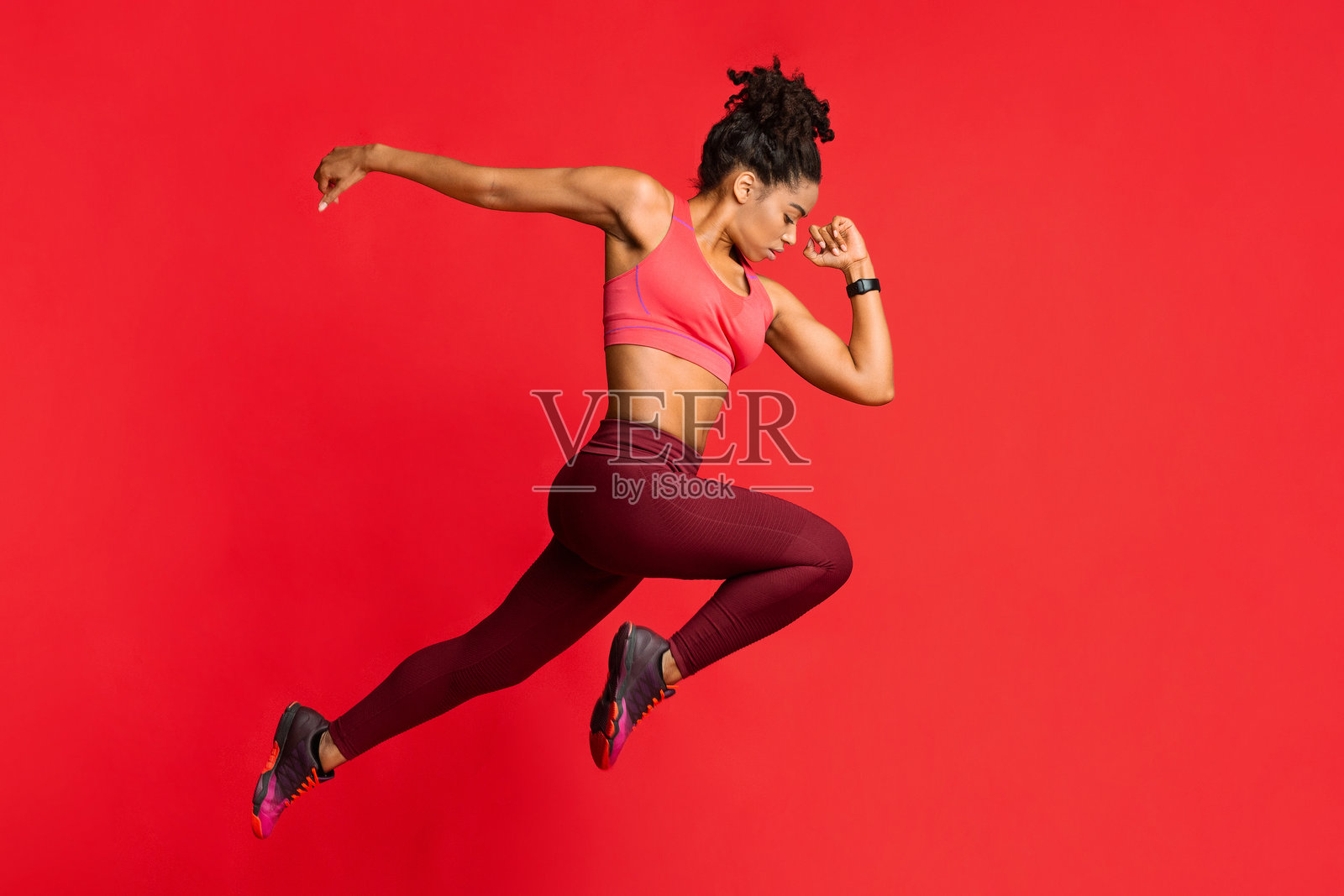 运动女孩在红色背景下跑步照片摄影图片