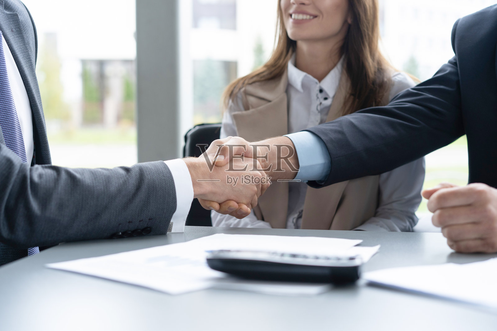 年轻商务人士在会议室达成协议握手。照片摄影图片