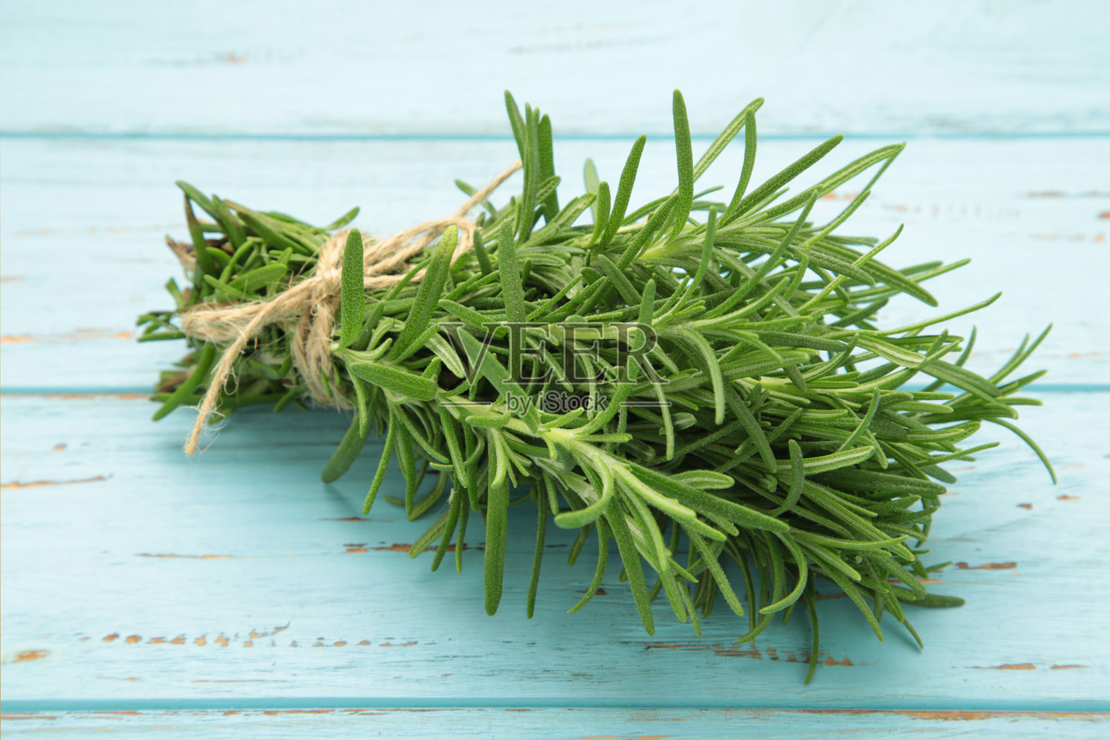 新鲜迷迭香束放在蓝色木背景上照片摄影图片