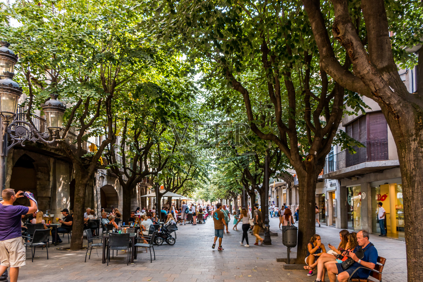 游客在加泰罗尼亚的赫罗纳市漫步，探索城市的景点和街道。历史建筑。照片摄影图片
