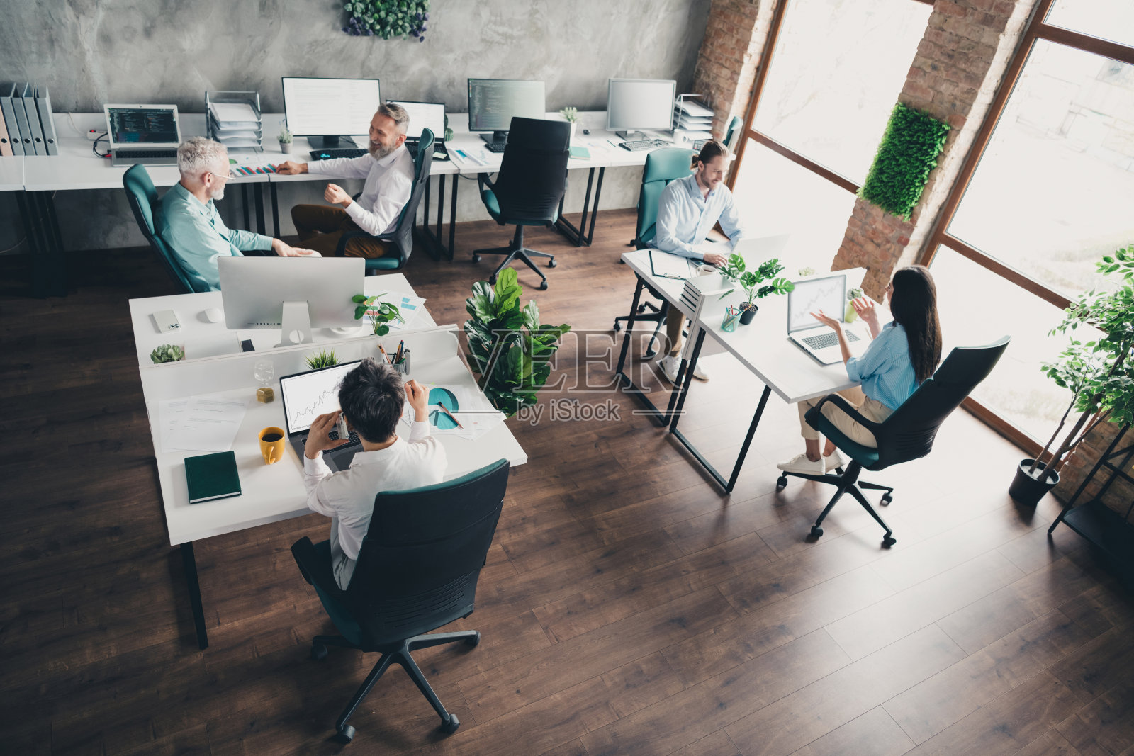 团队成员在舒适的现代办公室阁楼房间内一起工作，全身照照片摄影图片