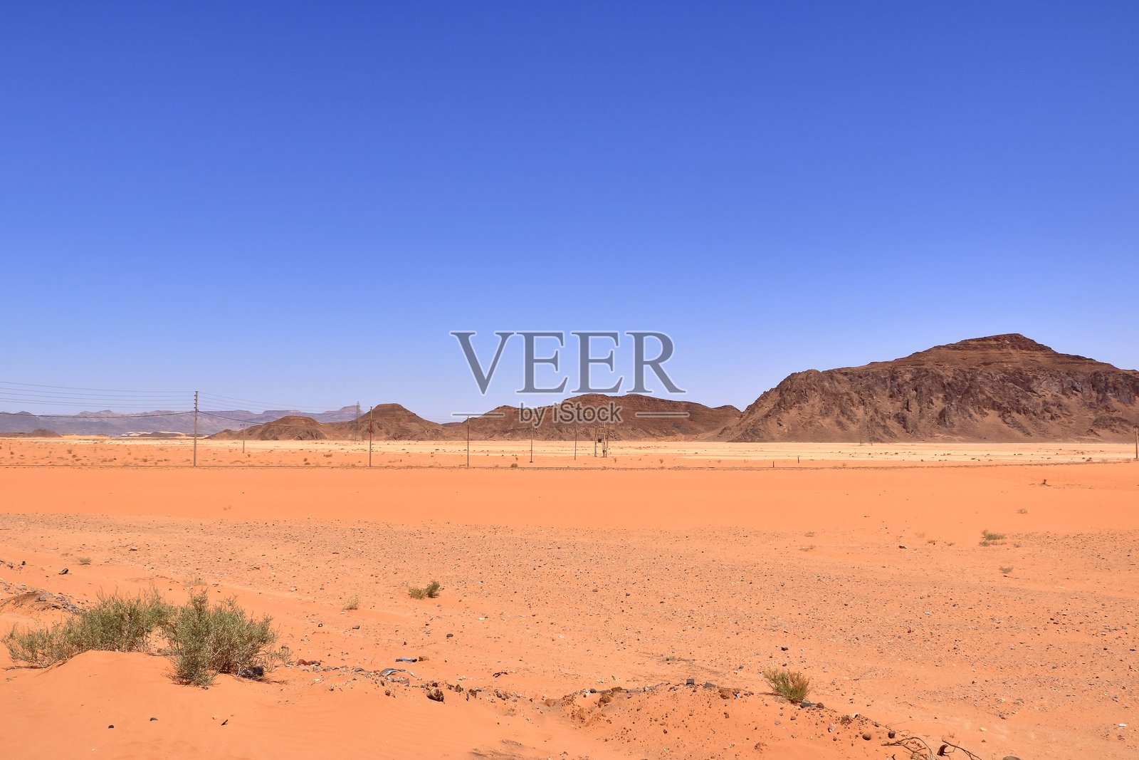 约旦瓦迪拉姆沙漠中几乎被沙子覆盖的旧铁轨照片摄影图片