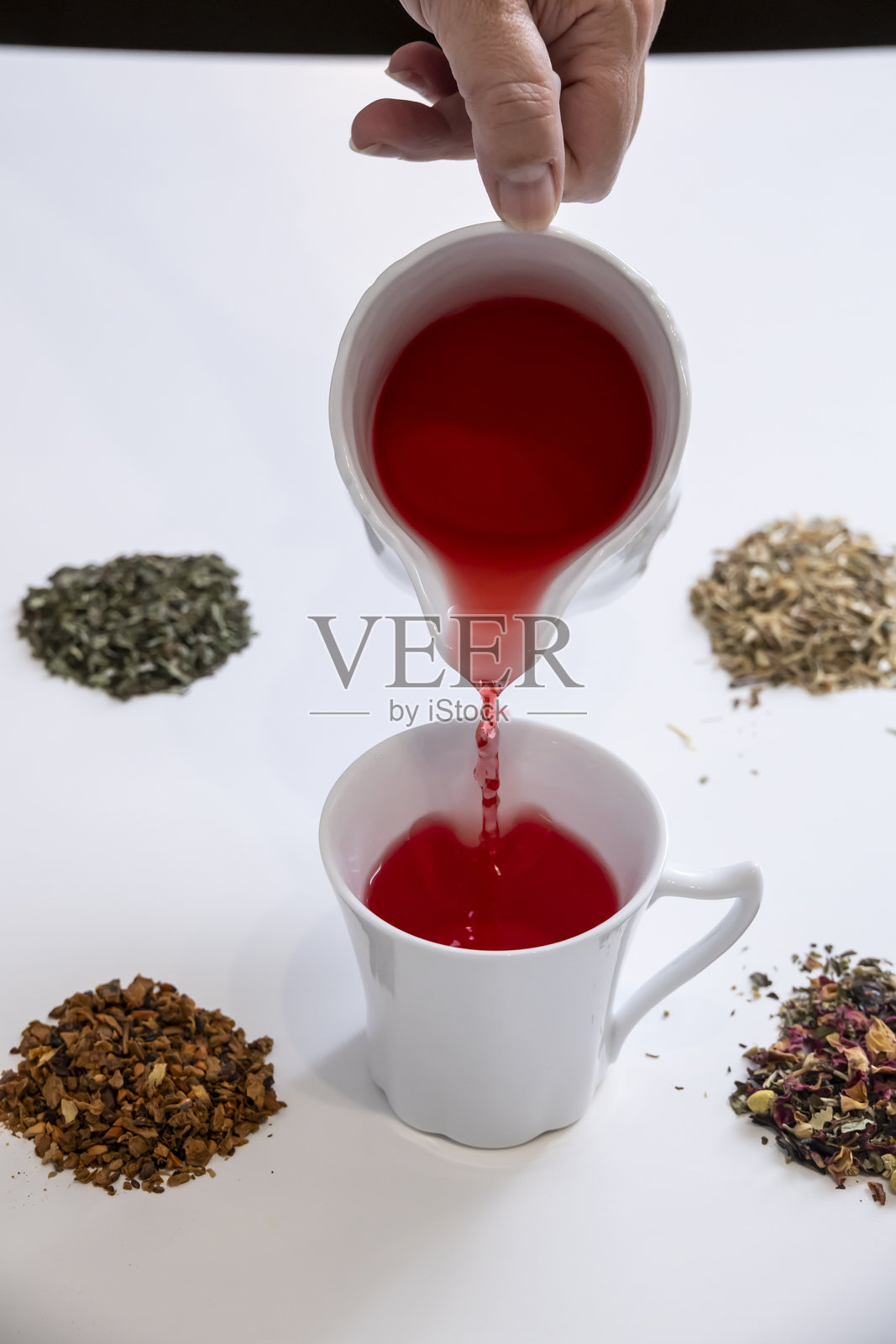 将茶倒入优雅的白色瓷杯中照片摄影图片