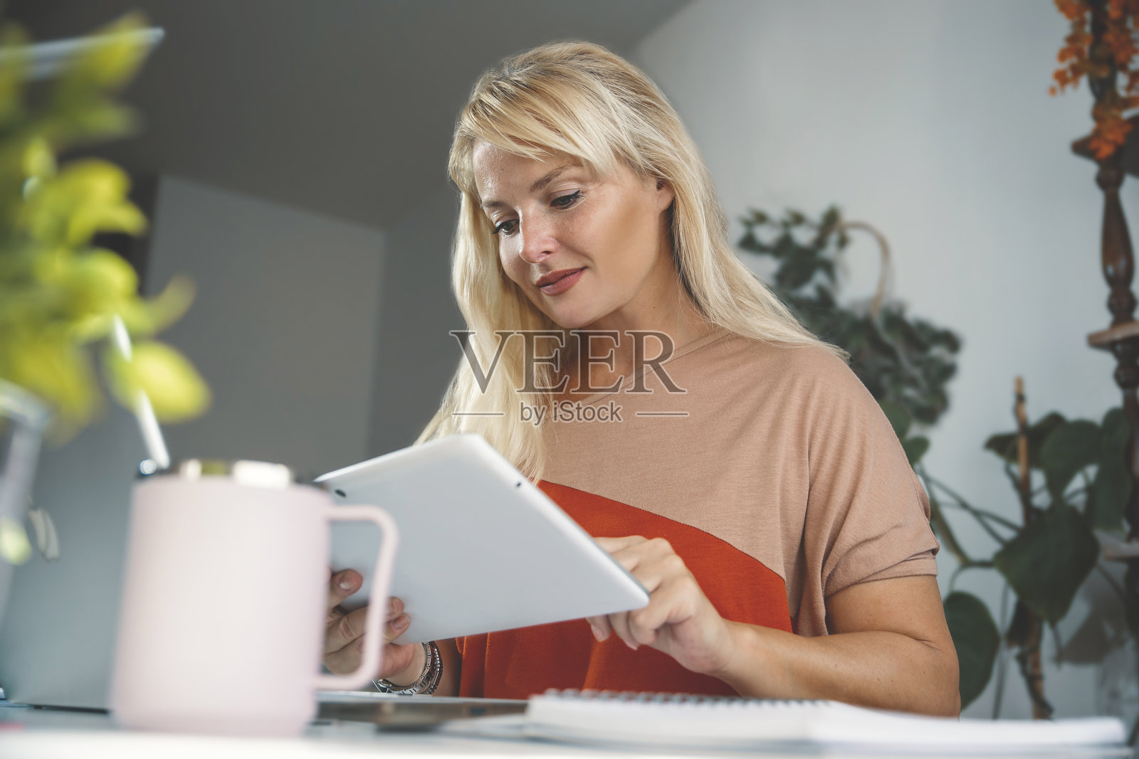 女人在办公室书桌前使用平板电脑照片摄影图片