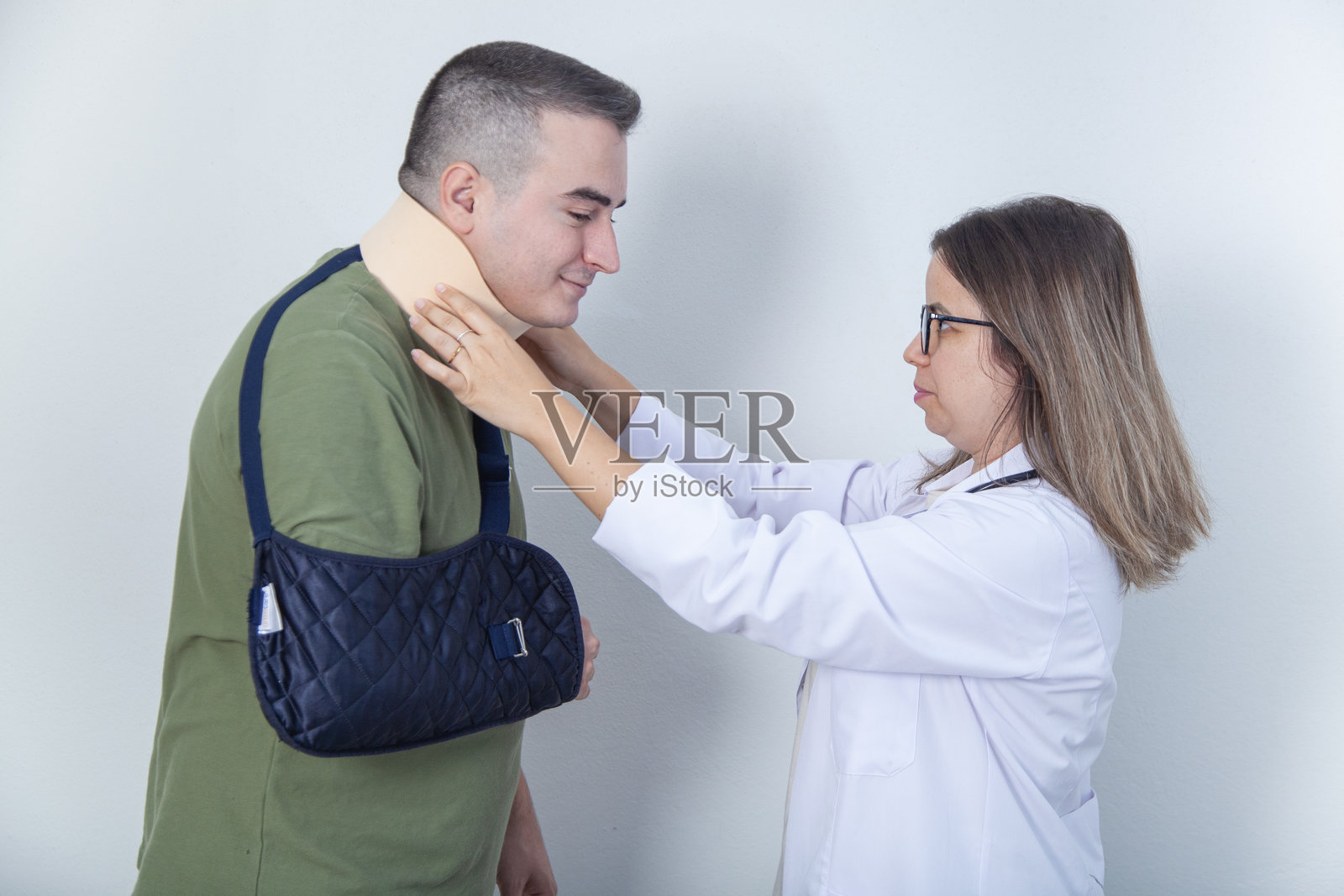 女医生为受伤男子戴上颈托。照片摄影图片