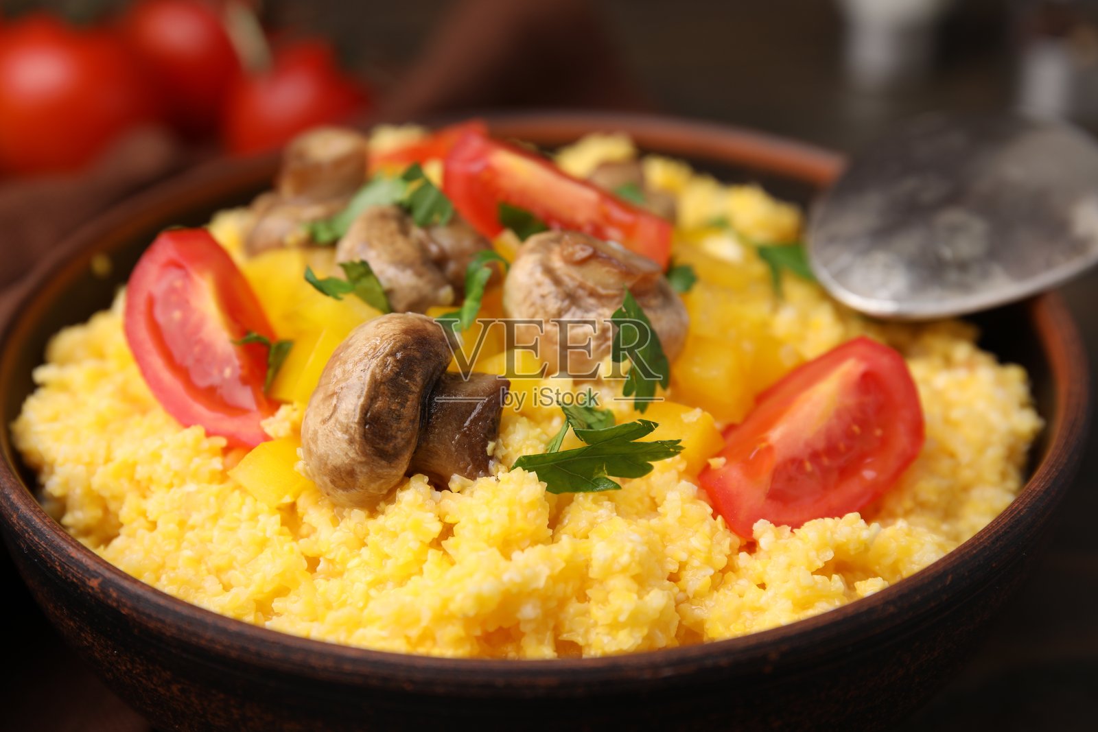 美味的玉米面与番茄、辣椒和蘑菇在桌子上的碗中，特写镜头照片摄影图片