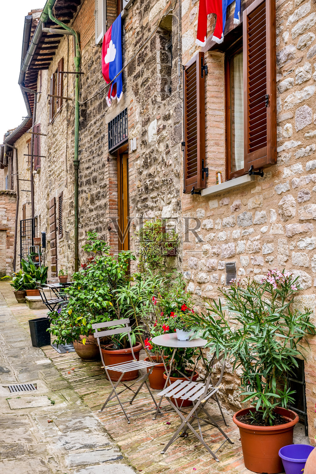 乌姆布里亚古堡古比奥中世纪中心的一条美丽小巷，装饰着植物和帷幕照片摄影图片