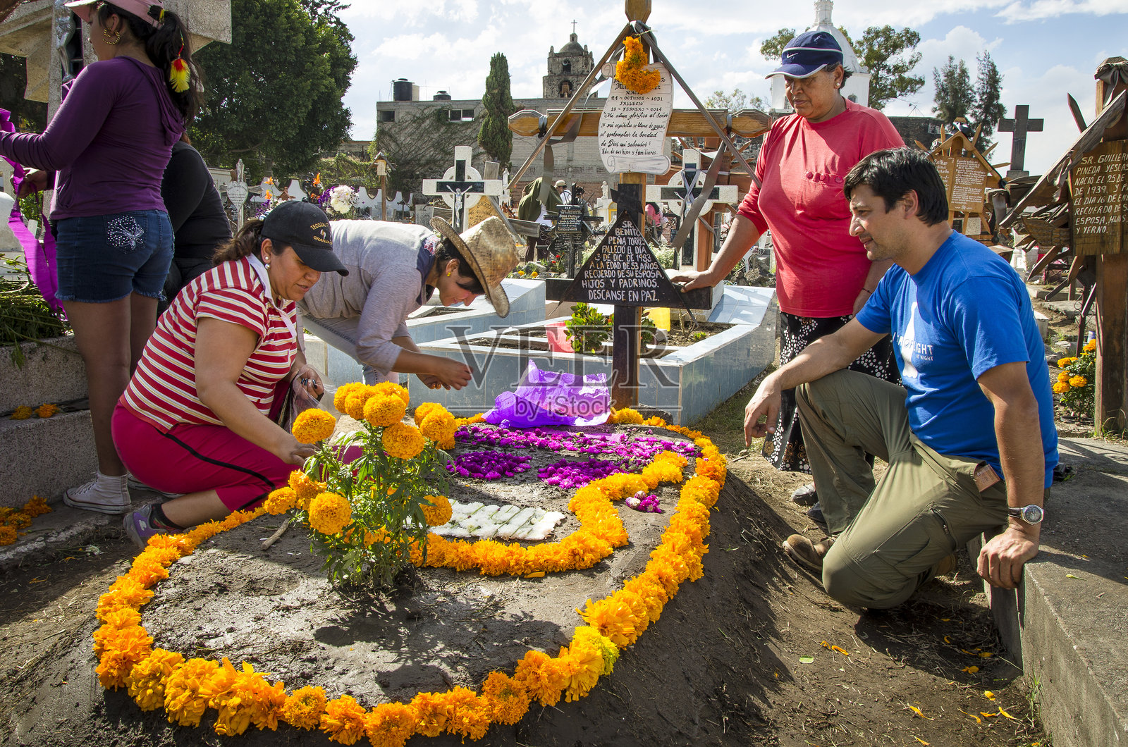 人们在亡灵节期间装饰家人的坟墓照片摄影图片
