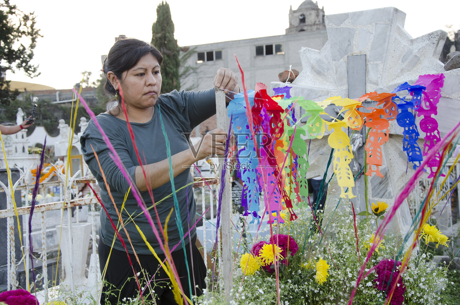 人们在亡灵节期间装饰家人的坟墓照片摄影图片