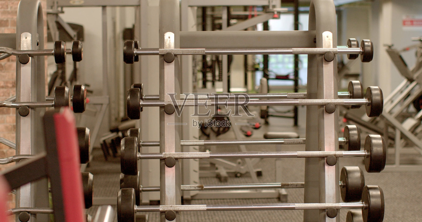 带有哑铃和锻炼器材的健身房，适合活跃人士照片摄影图片