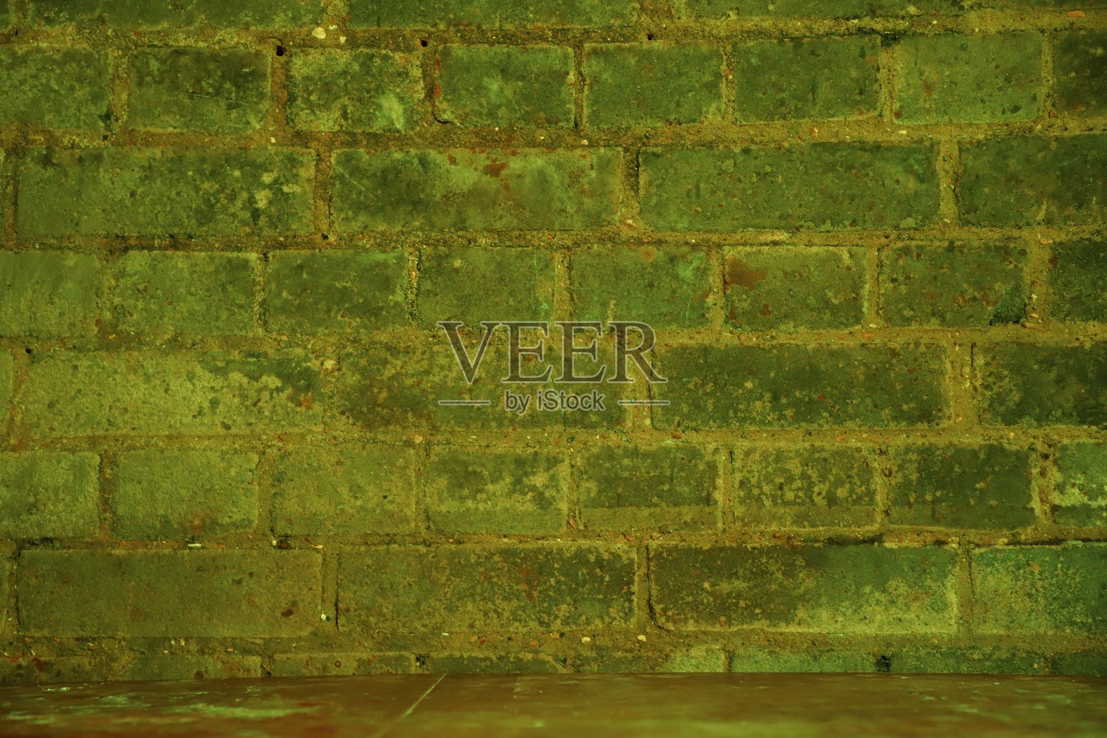 绿色砖墙悬挂在桌子边缘上照片摄影图片