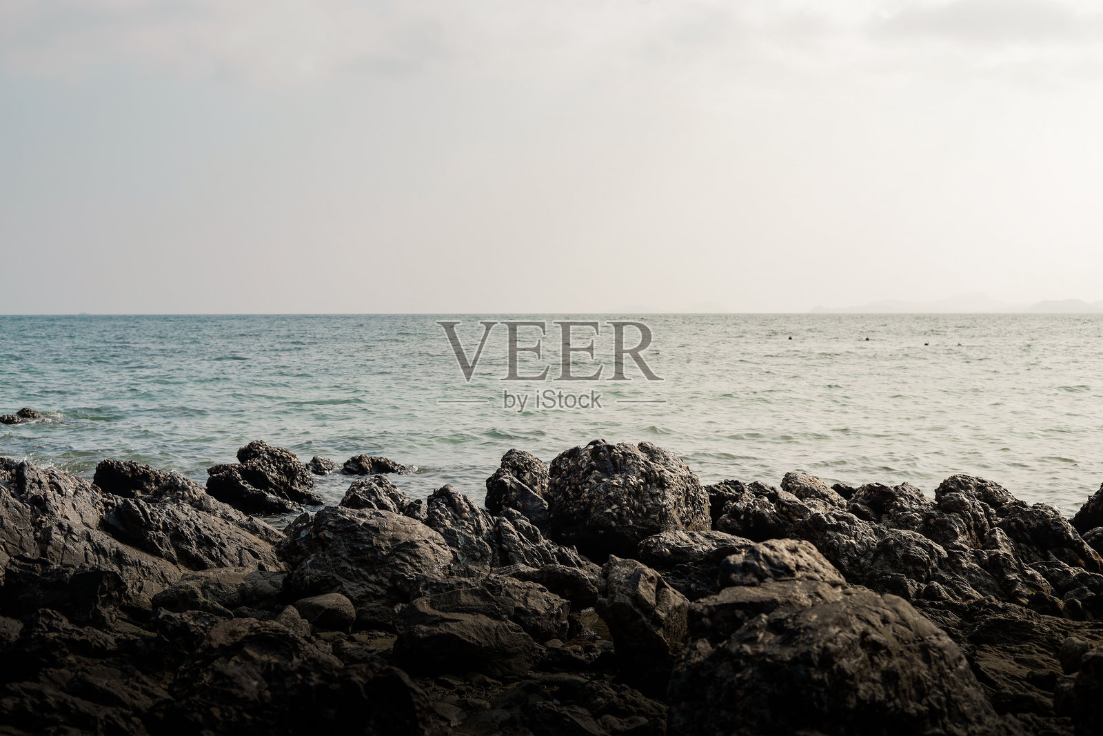 傍晚的岩石和辽阔海洋的风景。照片摄影图片