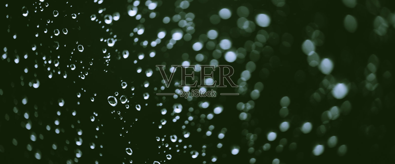 带有雨滴的单色氛围背景。湿润的窗户上有雨滴和污垢斑点的特写。模糊的极简风格脏窗玻璃背景，近距离展示雨滴。照片摄影图片