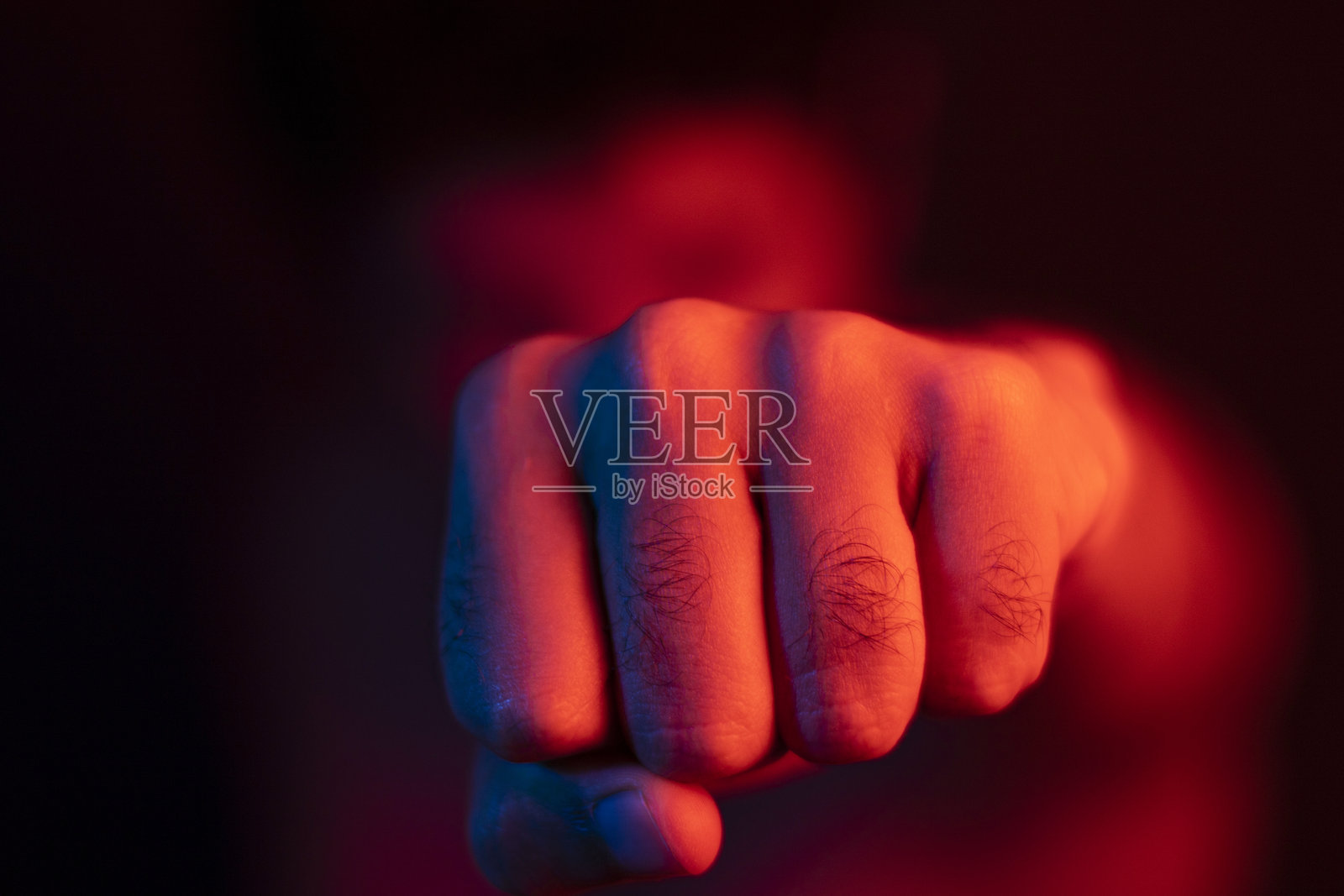 健壮男人挥拳，拳击运动，红色模糊背景照片摄影图片