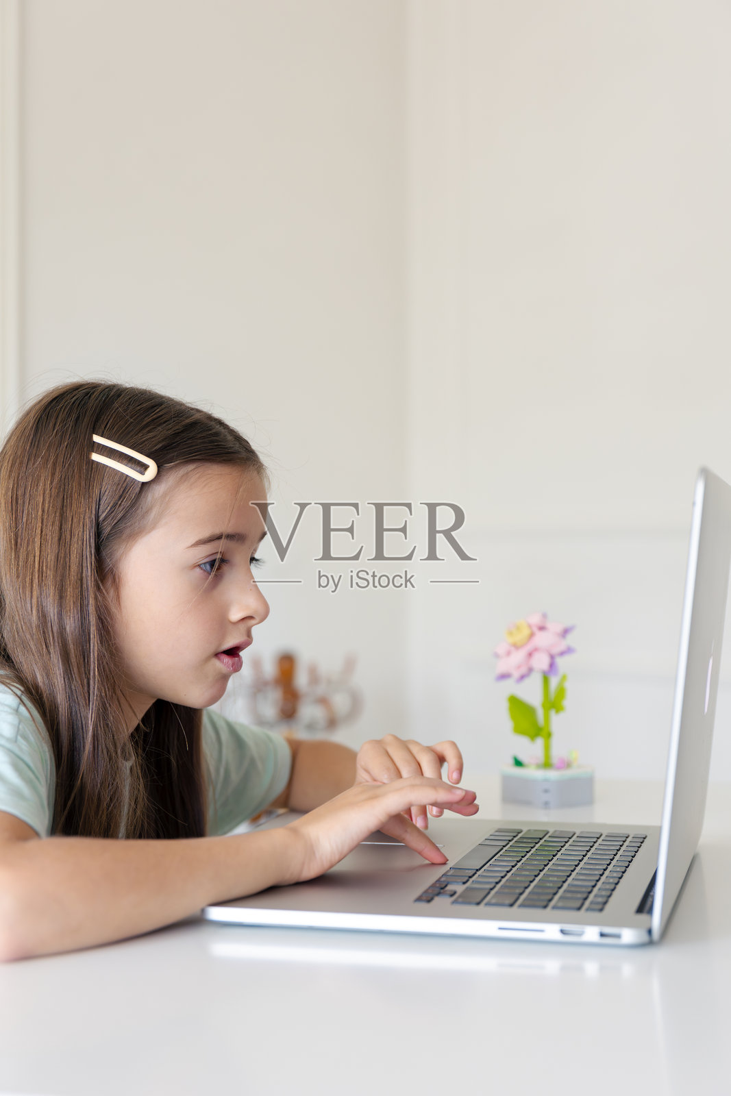 一名女学生在家在线学习。女孩正在笔记本电脑键盘上打字。照片摄影图片