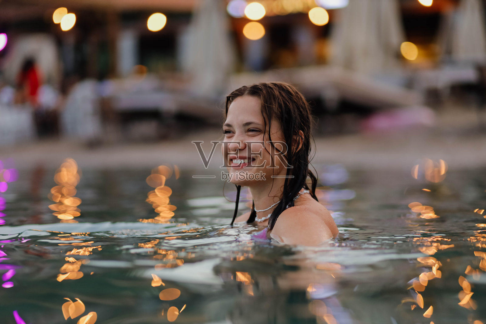 美丽的女人在傍晚时分游泳于海中照片摄影图片