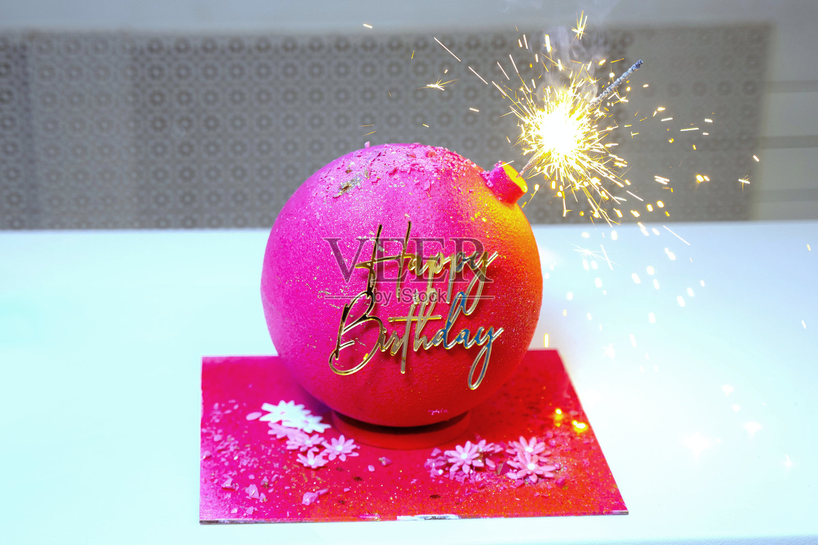 粉色生日蛋糕上挂着金色的生日快乐横幅。照片摄影图片