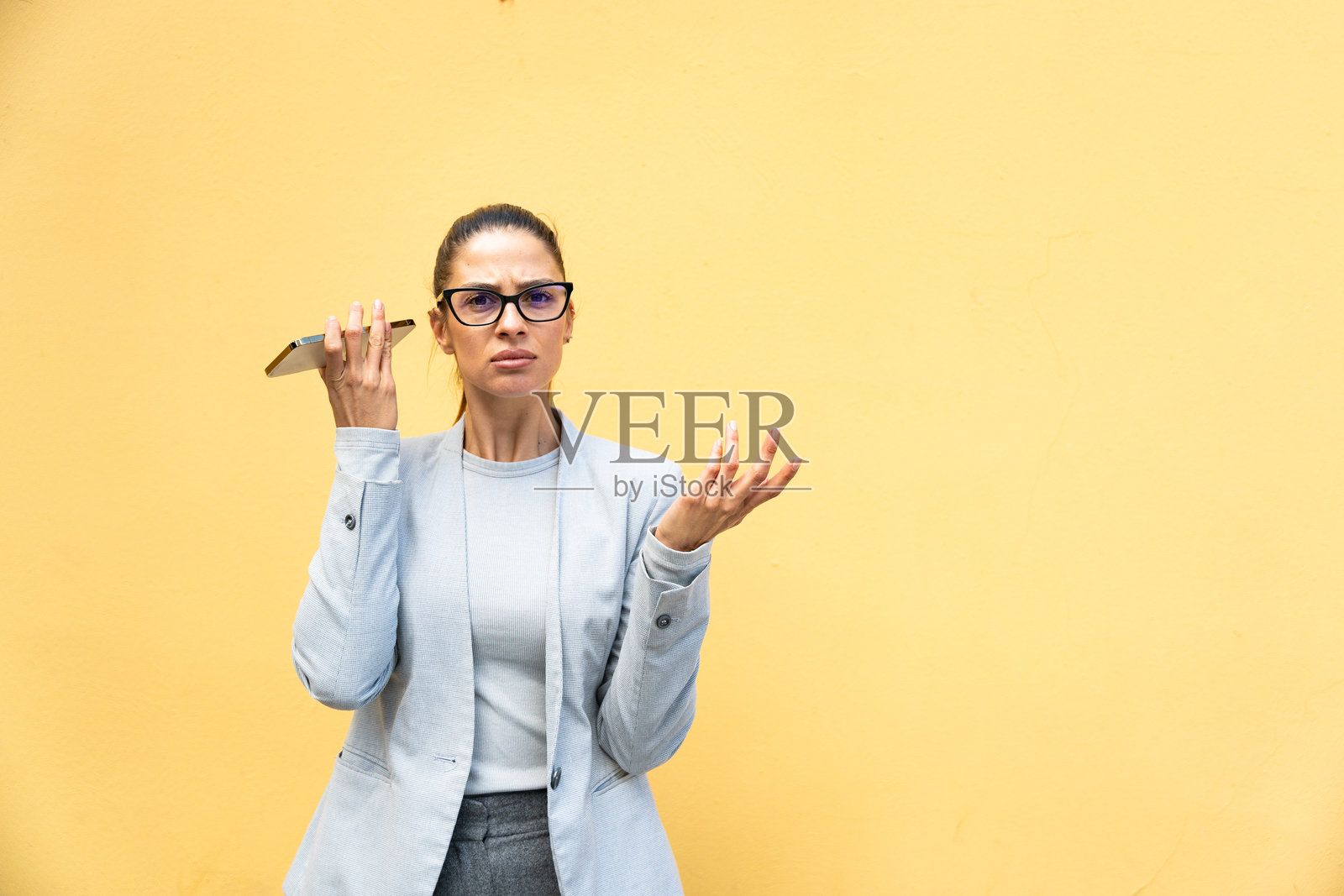 在城市街道上听语音邮件的焦虑女商人照片摄影图片