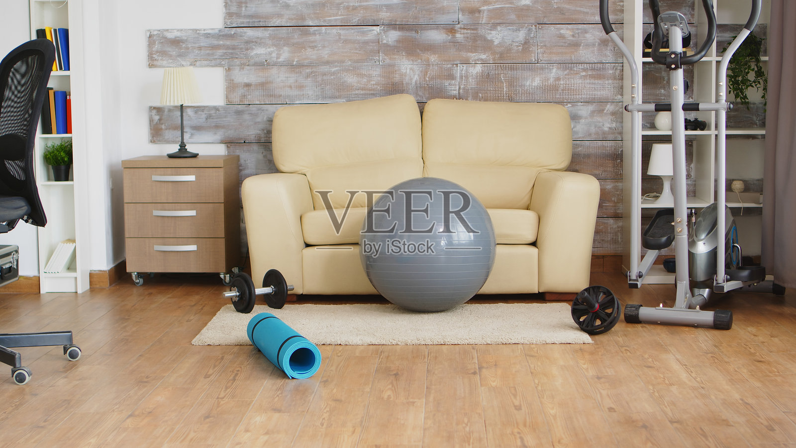 房间里的椭圆形健身器和健身球照片摄影图片