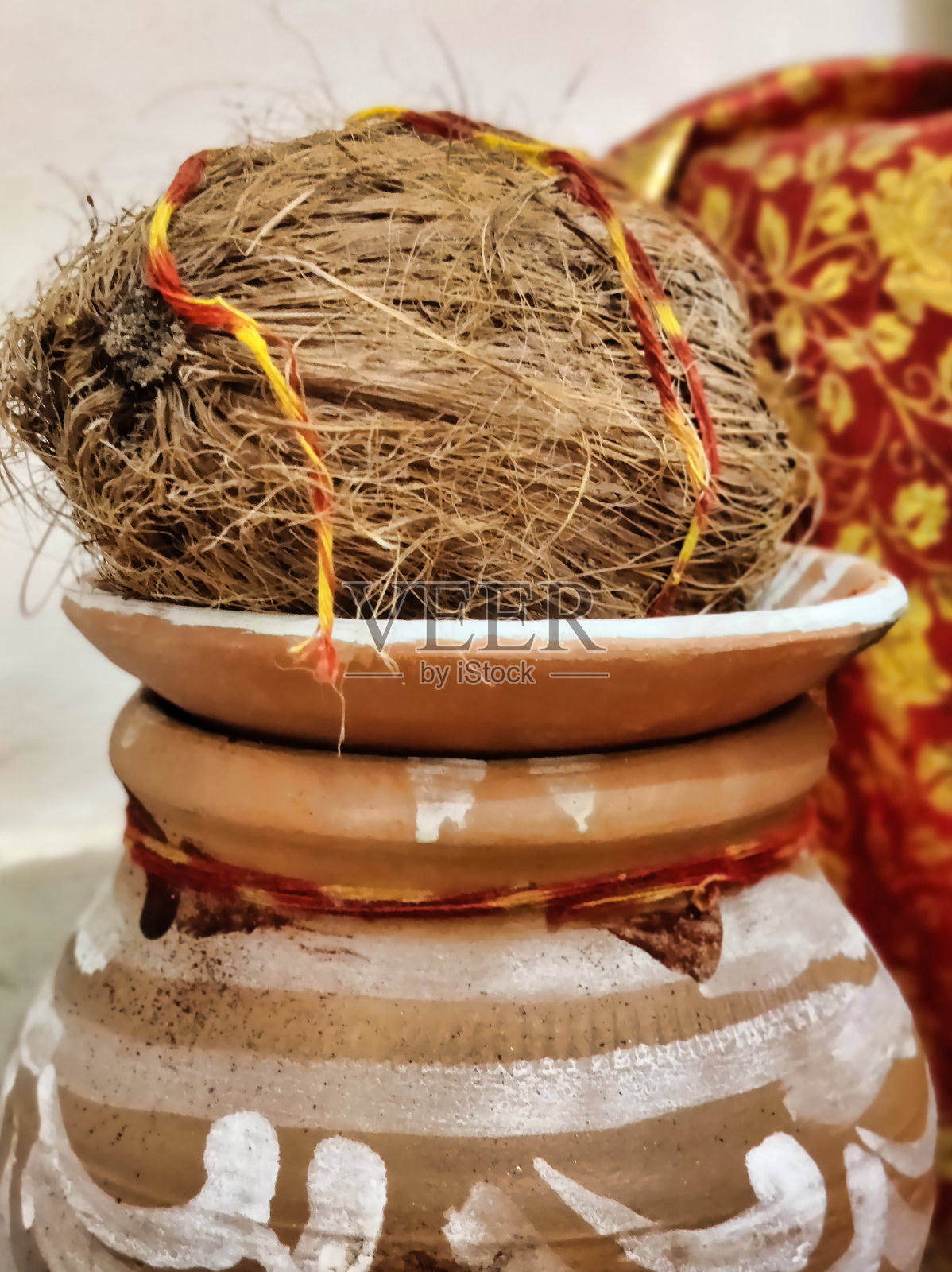 陶罐中的椰子，系着红色和黄色的丝带照片摄影图片