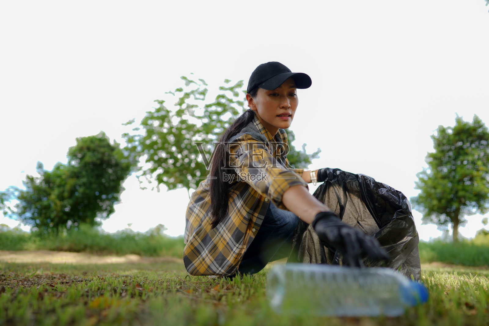 女人收集垃圾和塑料水瓶照片摄影图片
