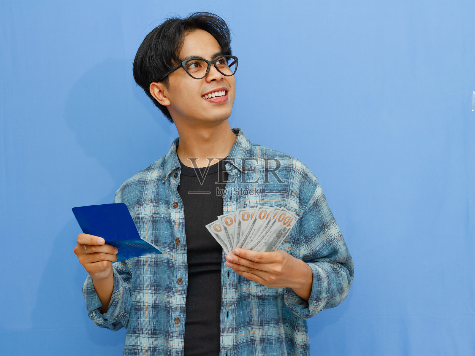 拿着钱和银行存折，思考金融问题的快乐亚洲成年男子肖像照片摄影图片