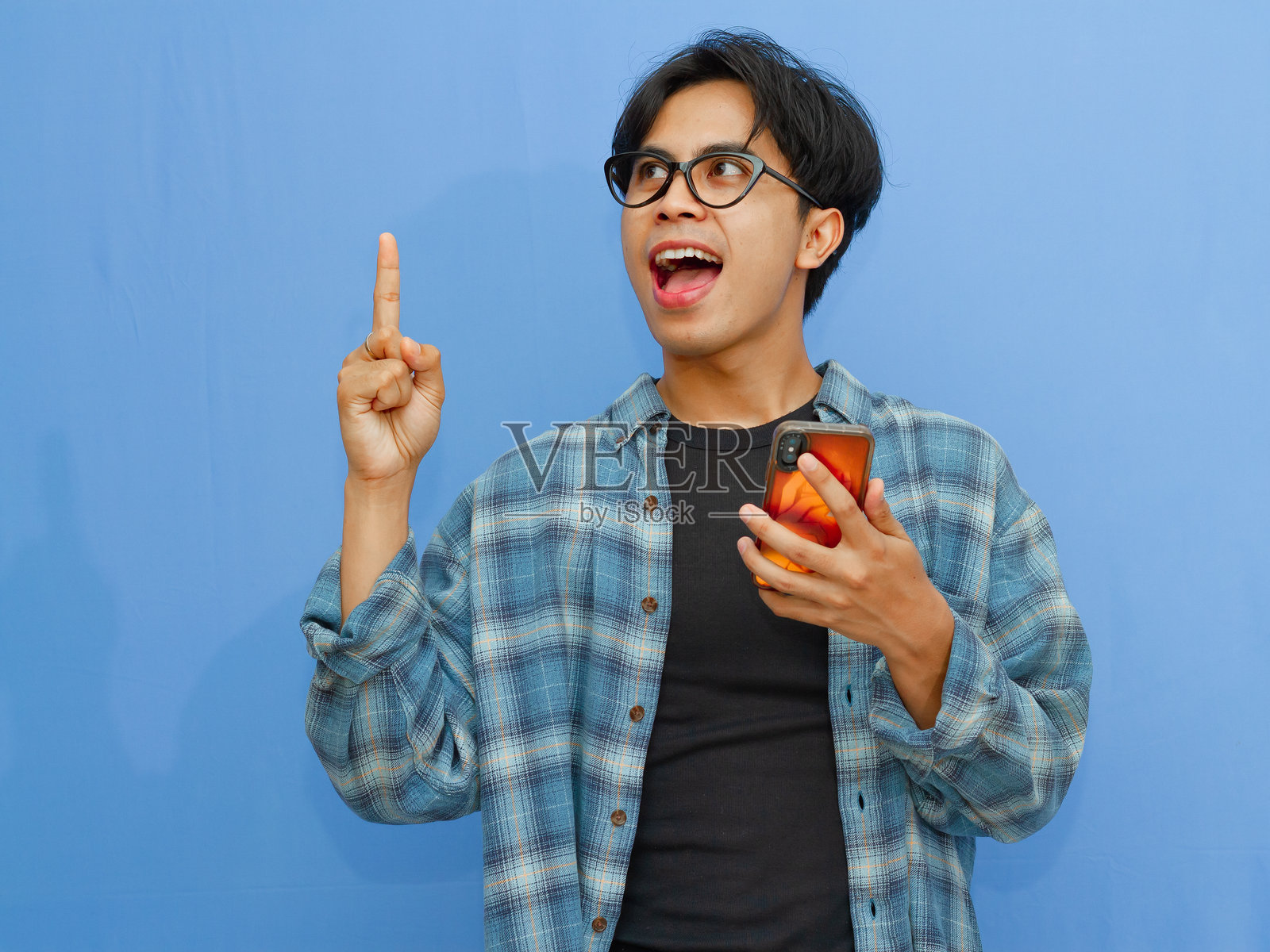 兴奋的亚洲男人举起一根手指，想到了好主意照片摄影图片