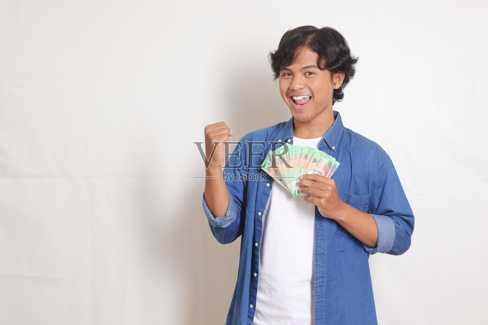 手持印尼盾的亚洲男子肖像照片摄影图片