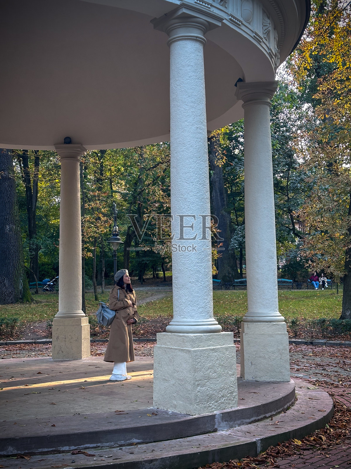 秋季公园里站在凉亭下的人照片摄影图片