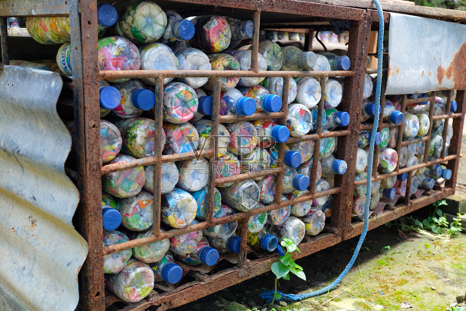 装满回收塑料瓶的生锈金属笼子照片摄影图片
