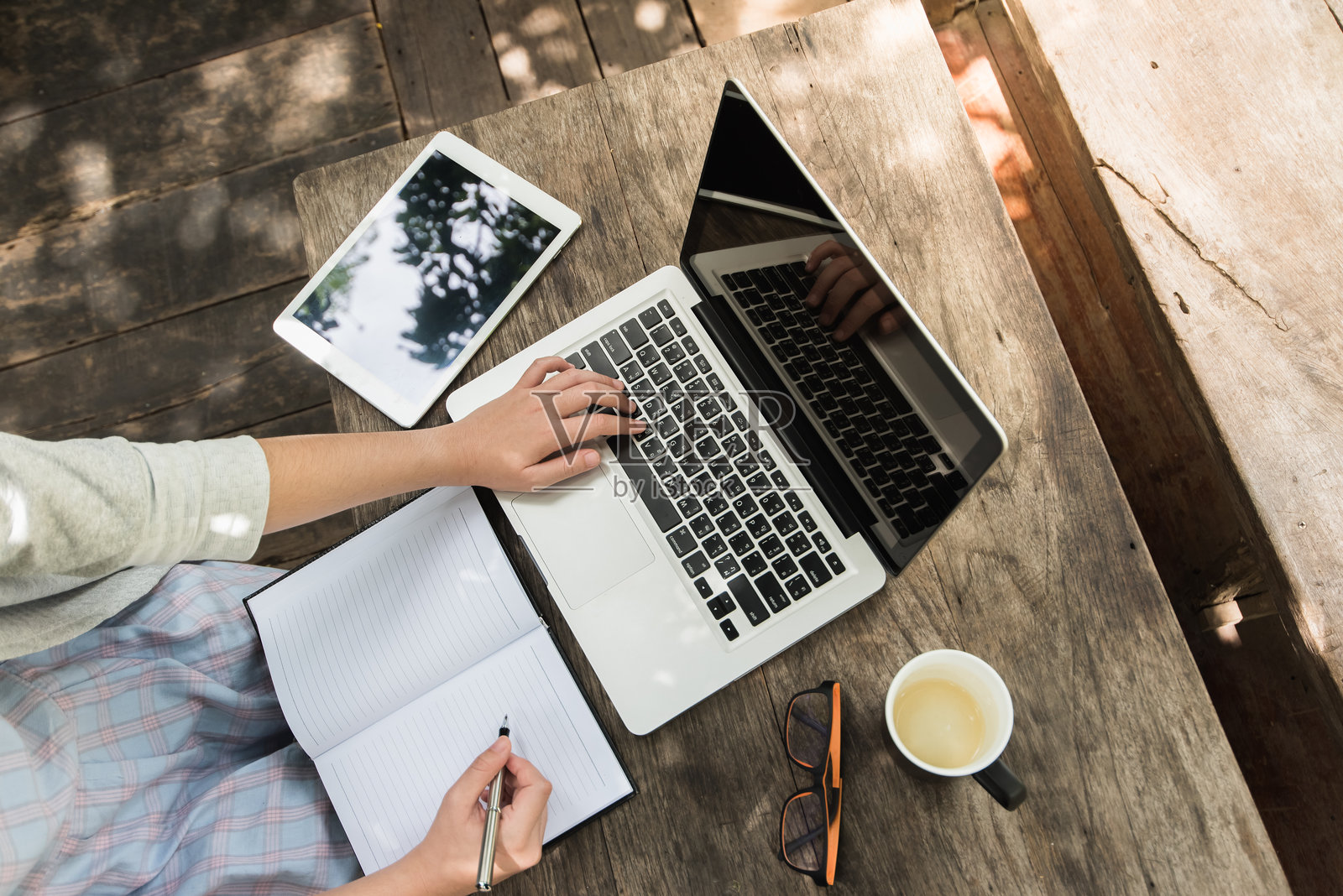 女性在木桌上使用笔记本电脑写作的中段画面照片摄影图片