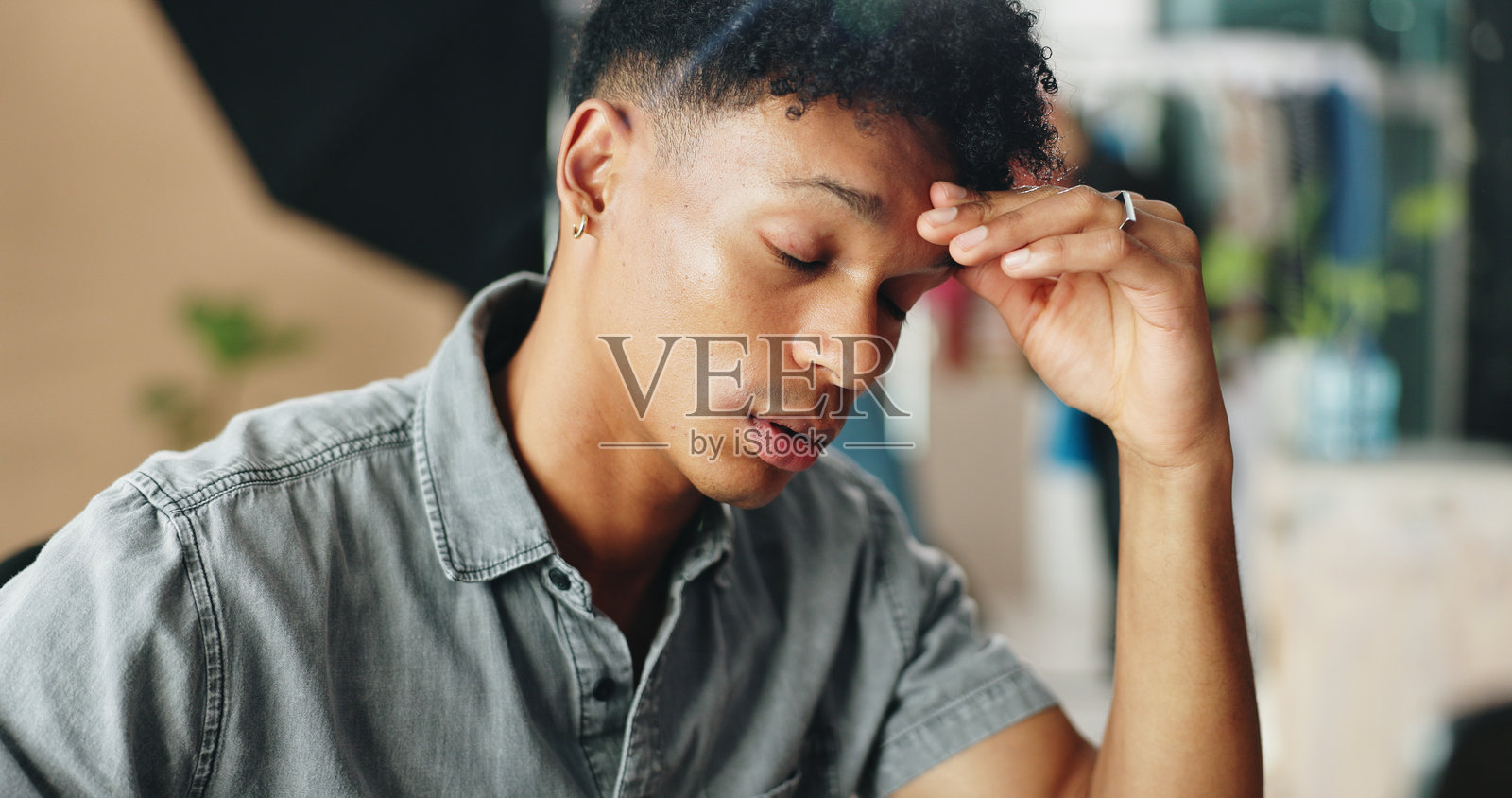 办公室中因压力、过度工作和心理健康问题而感到头痛的商务人士。专业员工在工作场所经历偏头痛，感到不适、紧张和疲惫。照片摄影图片