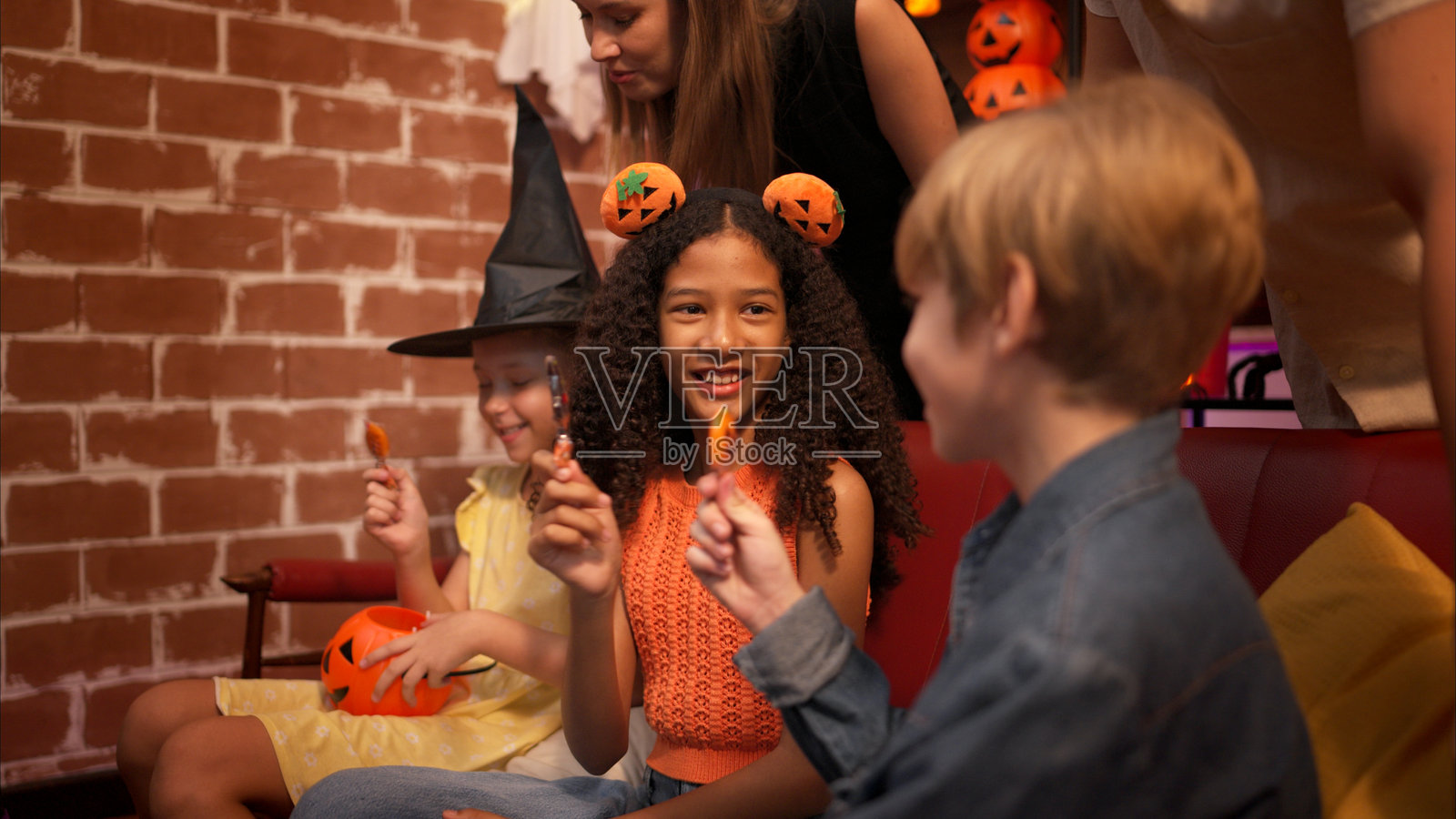 父母和孩子们正在享受万圣节庆祝派对。照片摄影图片