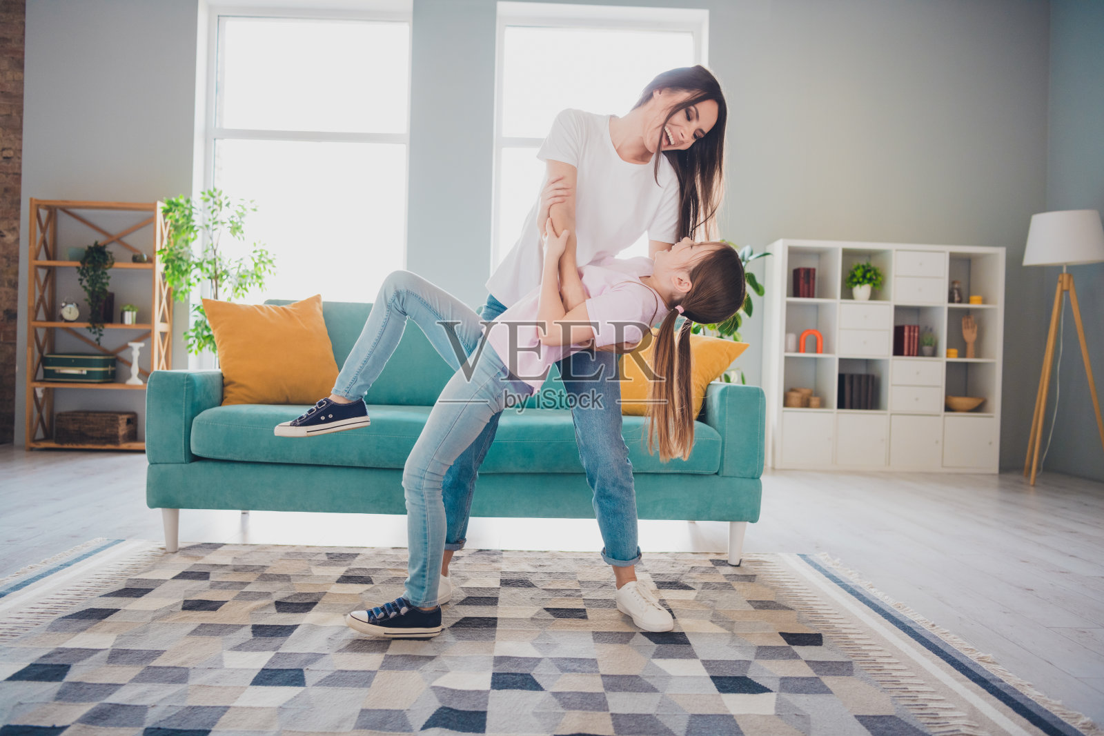 快乐、可爱的母亲与女儿在温馨的客厅里共度时光照片摄影图片