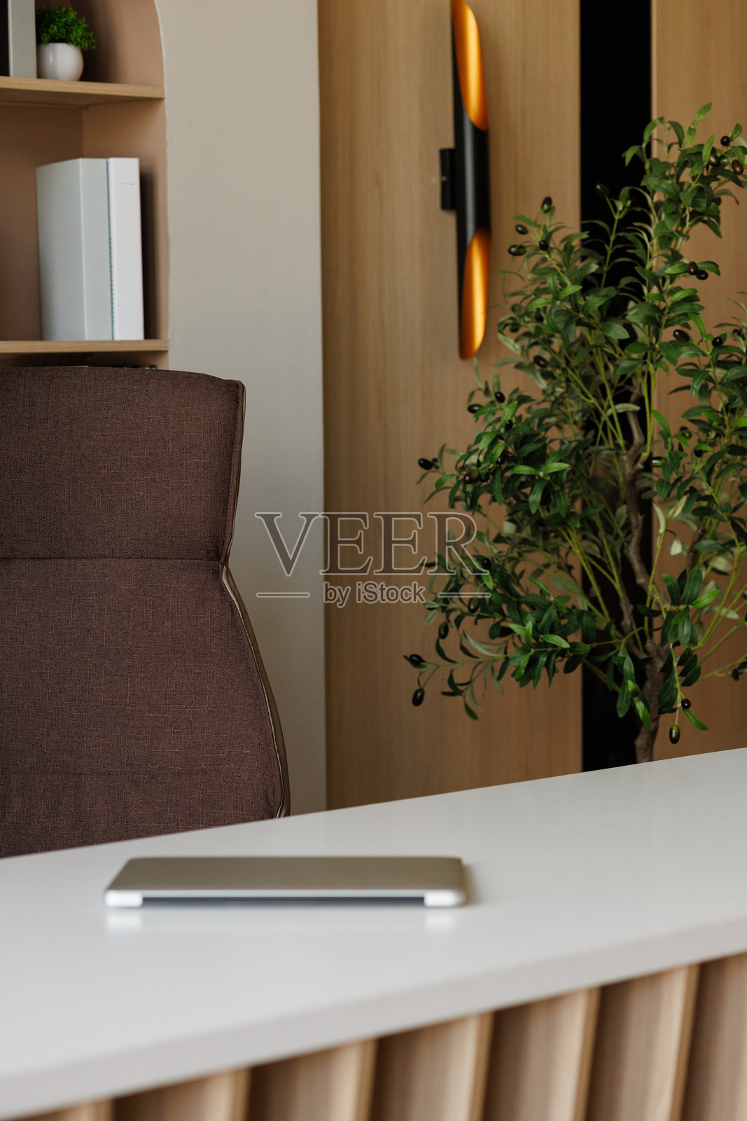 一把棕色椅子放在桌子前，桌上有一部电话。照片摄影图片