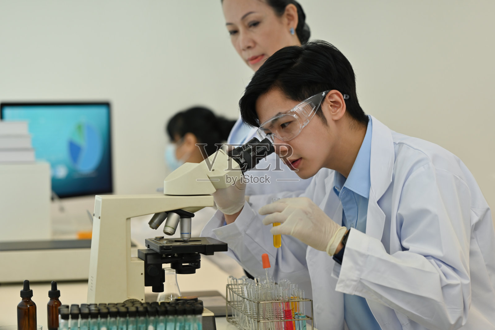 年轻的亚洲科学家或研究人员在实验室里与同事一起使用显微镜进行研究照片摄影图片