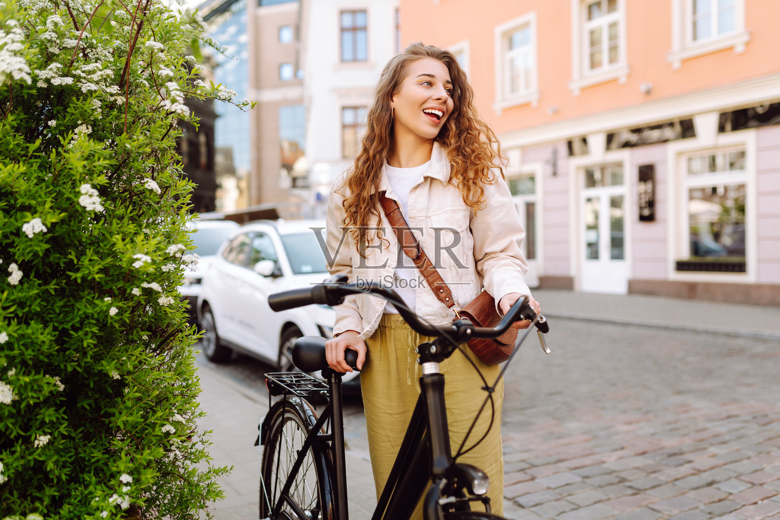 快乐的女人在城市街道上骑自行车。照片摄影图片