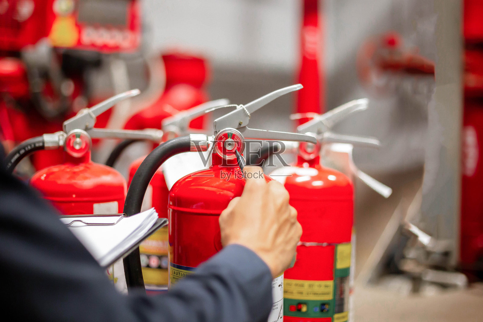 工程师在消防控制室检查灭火器罐体照片摄影图片