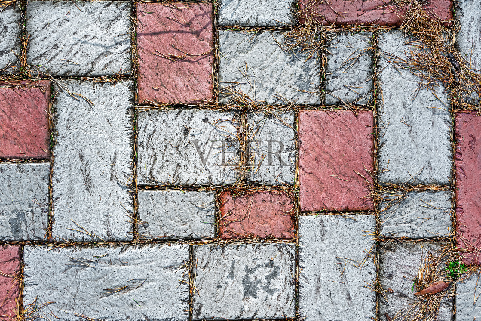 旧人行道上覆盖着从树上掉落的干松针。照片摄影图片