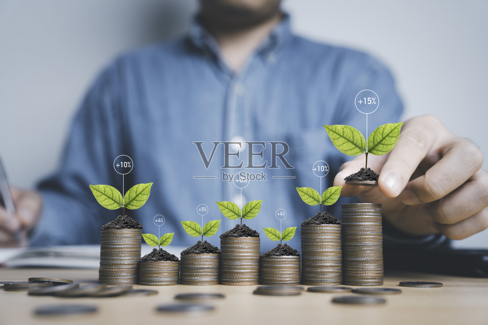 商人将硬币放在堆叠的硬币上，寓意着存款、投资和获得股息收益增长的概念。照片摄影图片