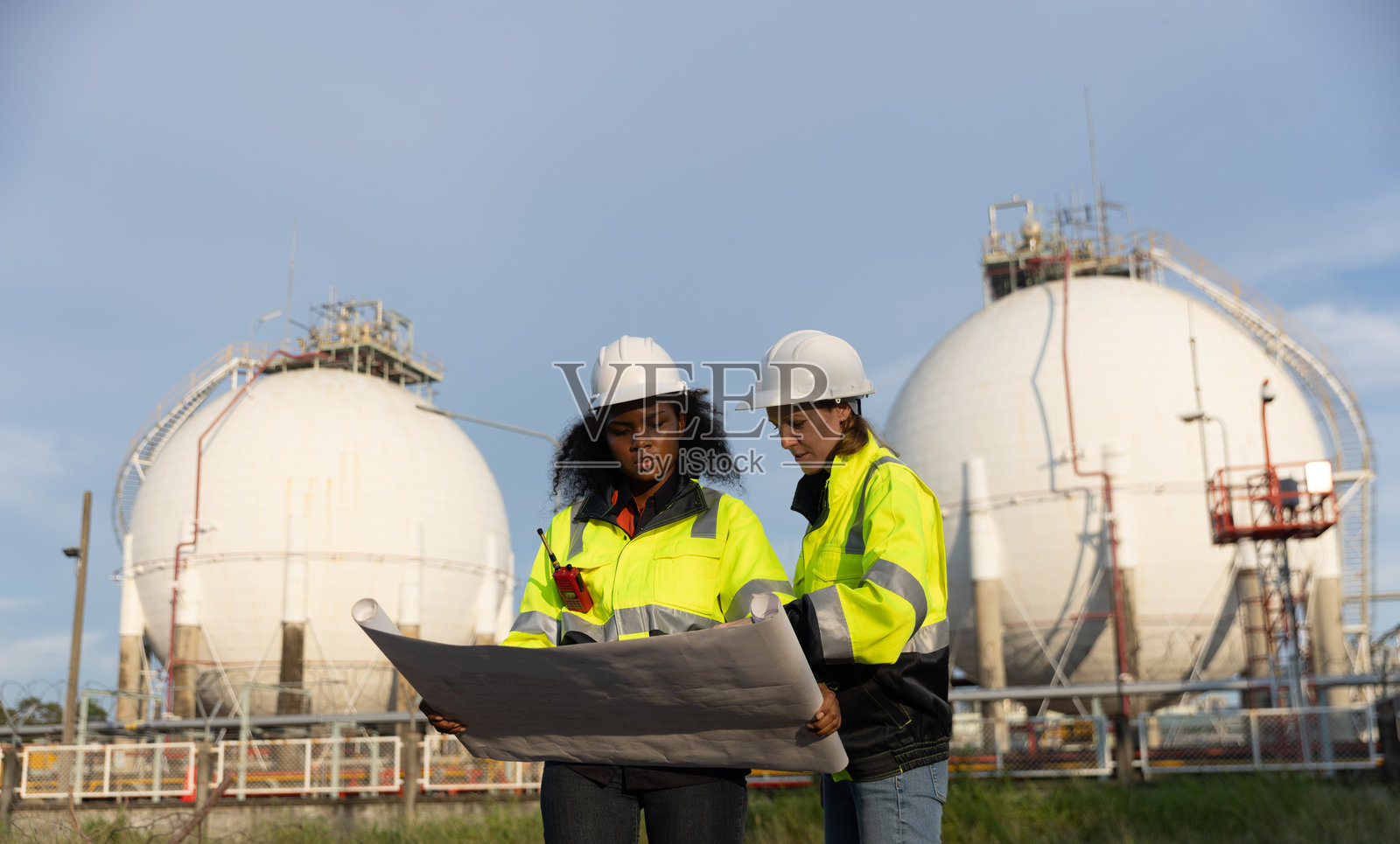 石油化工女工程师与黑人女工程师探讨石油天然气生产照片摄影图片