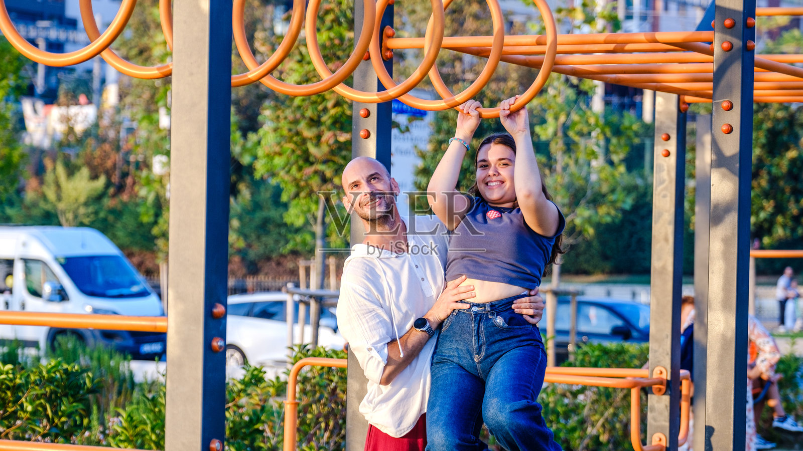 一个稍微超重的少女在秋天的公园里和她的父亲玩耍照片摄影图片