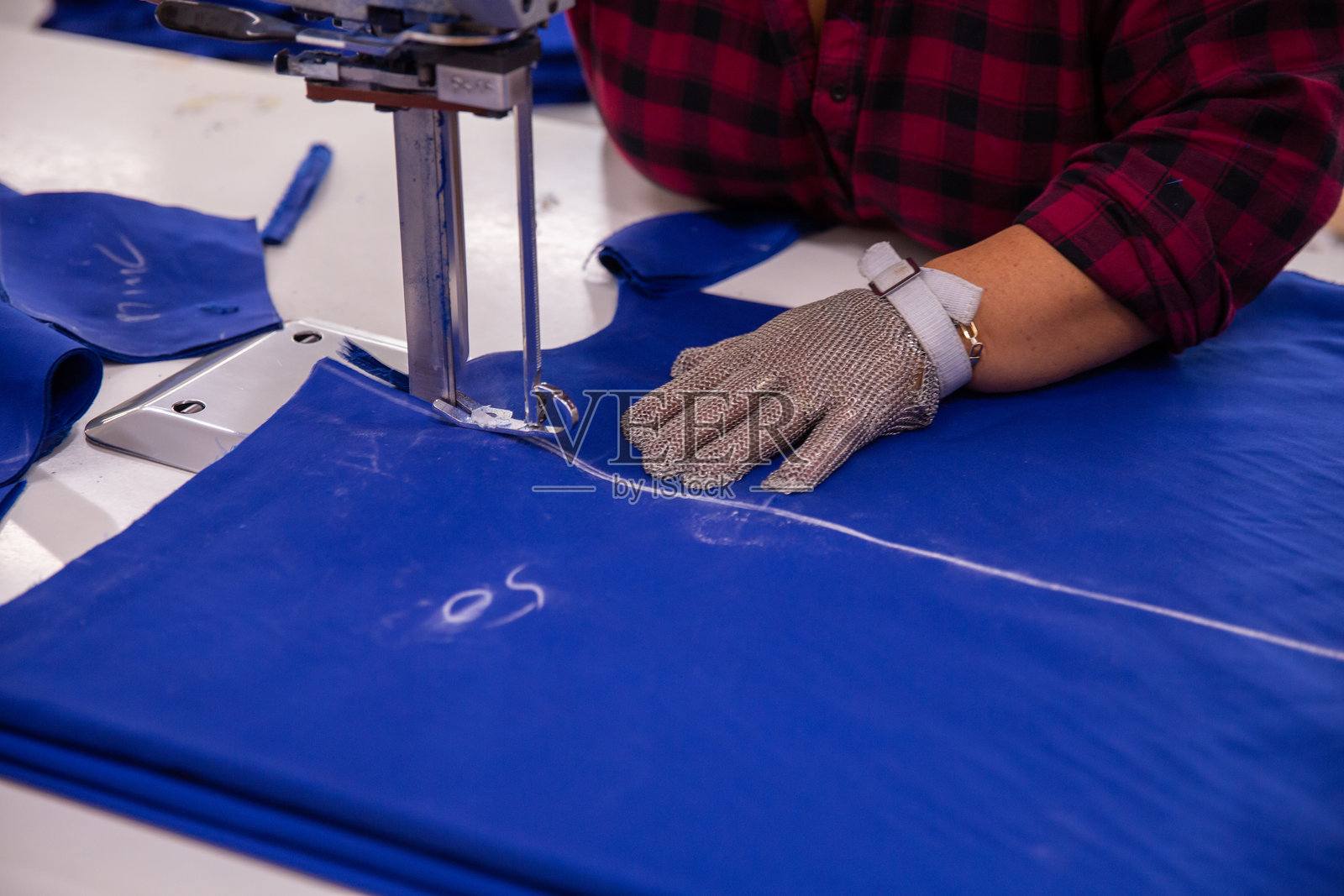 特写镜头下的女性正在使用布料切割机照片摄影图片