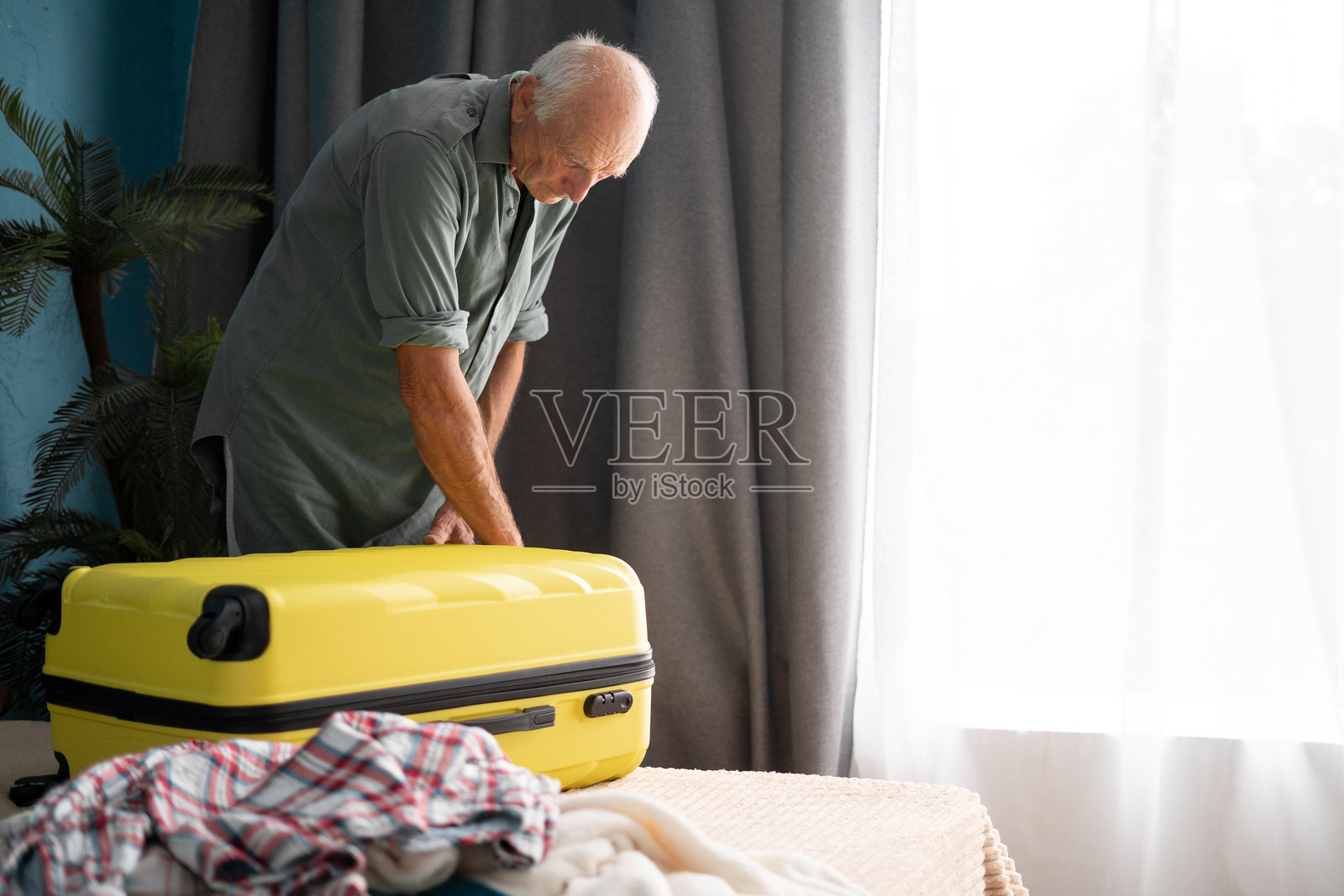 老年男人在床上打包行李准备旅行照片摄影图片