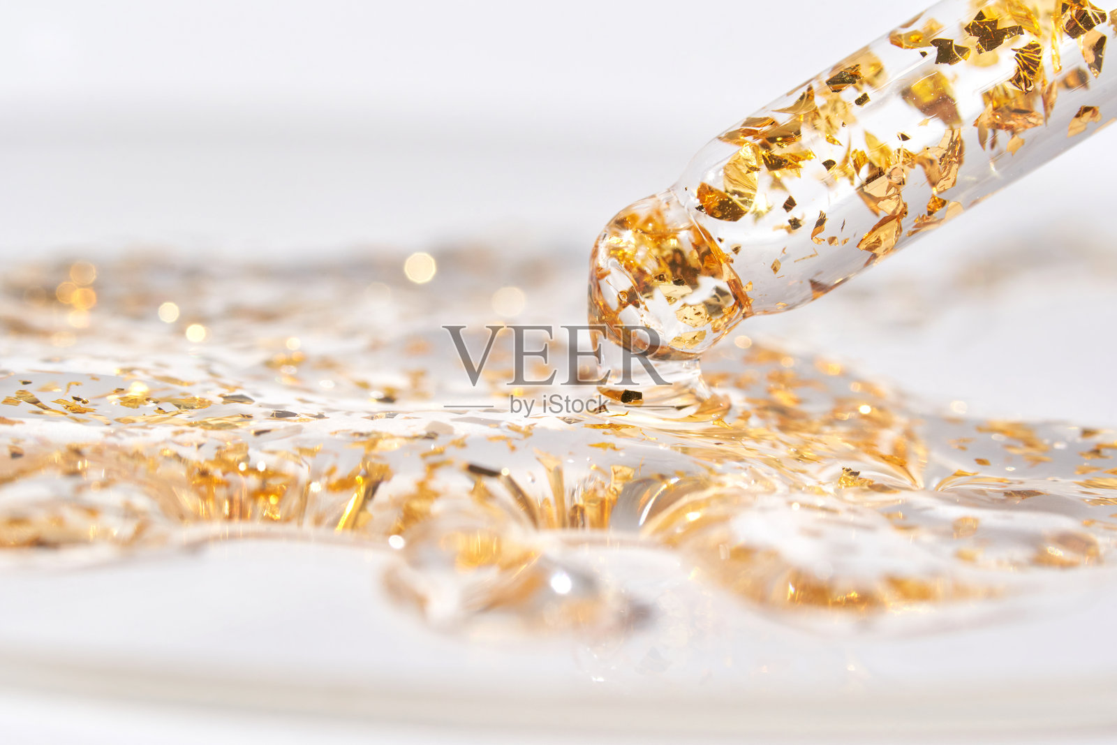奢华护肤精华液与金箔在玻璃滴管瓶中照片摄影图片